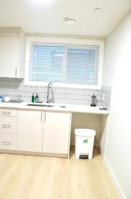 a kitchen with white cabinets and a sink and a window at Secondary Suite, Separate Entrance NW Calgary in Calgary