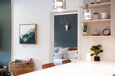 a living room with a bed and a mirror at Hemlock Hangout by Revelstoke Vacations in Revelstoke