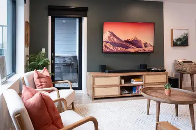 a living room with a tv and a table at Hemlock Hangout by Revelstoke Vacations in Revelstoke