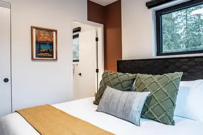 a bedroom with a white bed with a window at Hemlock Hangout by Revelstoke Vacations in Revelstoke