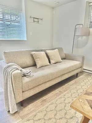a living room with a couch and a table at Homelike & cozy suite in Langley