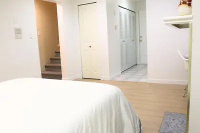 a bedroom with a white bed and a hallway at Pristine 3 Beds 2 Washroom Guest Suite in Surrey