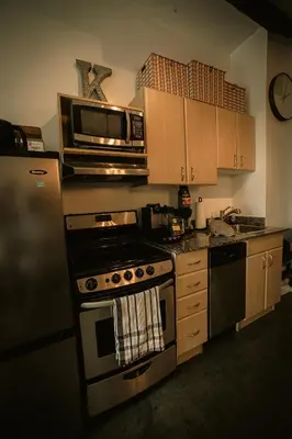 a kitchen with a stove and a microwave at 2 Full Beds, Free Parking Underground Heated, Rogers Place, 1 Bedroom Condo Downtown Central in Edmonton