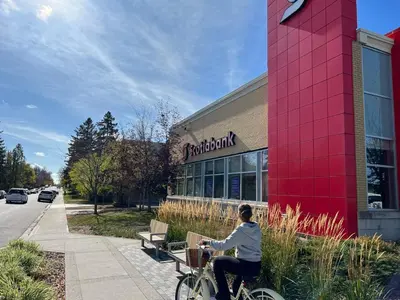 a woman riding a bike in front of a store at Lovely comfy home private bath in central Calgary in Calgary