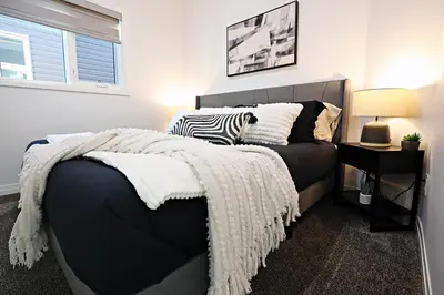 a bedroom with a bed with a blanket on it at Three King Beds,Central A/C,Fireplace,Park,Disney+ in Edmonton