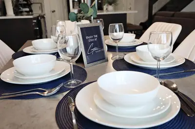 a table set with white plates and wine glasses at Three King Beds,Central A/C,Fireplace,Park,Disney+ in Edmonton