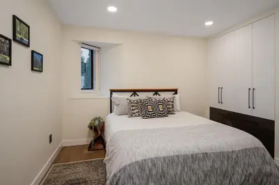 a bedroom with a bed and a white wall at 2BR in The Gables, Prime Location, Steam Shower, Heated Flooring, Wood Burning Fireplace in Whistler