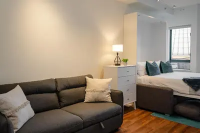 a living room with a couch and a bed at Studio in Market Pavilion, Private Balcony, Common Hot Tub, Epic Village Location, Parking in Whistler