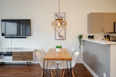 a kitchen and dining room with a wooden table and chairs at Studio in Market Pavilion, Private Balcony, Common Hot Tub, Epic Village Location, Parking in Whistler