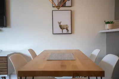 a dining room table with a picture of a goat on the wall at Studio in Market Pavilion, Private Balcony, Common Hot Tub, Epic Village Location, Parking in Whistler