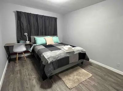 a bedroom with a bed with a desk and a chair at Cute Highland Park(Upper-A-Unit) in Calgary