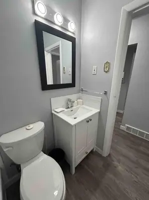 a bathroom with a toilet and a sink and a mirror at Cute Highland Park(Upper-A-Unit) in Calgary