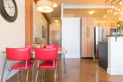 a kitchen with a table and red chairs at Be Vogue In Old Town Victoria in Victoria