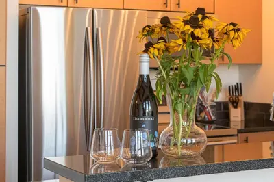 a bottle of wine and two glasses on a counter at Be Vogue In Old Town Victoria in Victoria