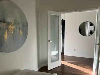 a bedroom with a mirror and a door to a room at Laid Back In Langford in Langford