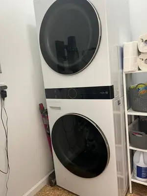 a microwave oven hanging on a wall next to a shelf at Laid Back In Langford in Langford