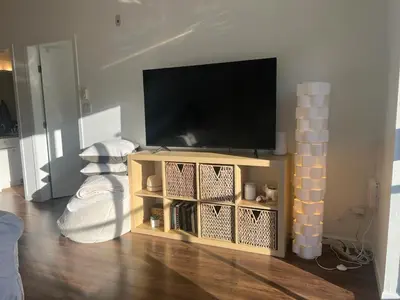 a living room with a flat screen tv on a stand at Laid Back In Langford in Langford