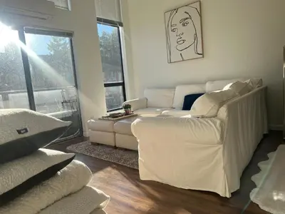 a living room with a white couch and windows at Laid Back In Langford in Langford