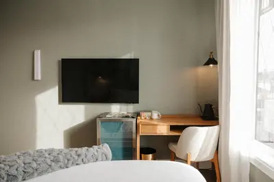 a living room with a desk and a television on a wall at Hotel Morado in Chilliwack