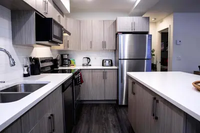 a kitchen with wooden cabinets and a stainless steel refrigerator at Absolutely Revy - Ground Level Condo in Revelstoke in Revelstoke
