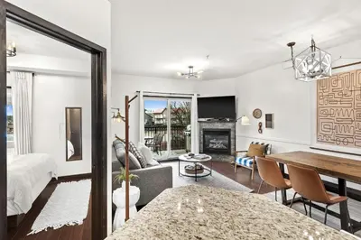 a living room with a bed and a dining room at Luxury 3B Mountain Views- Pool & Hot Tub -Sleeps 10 in Canmore