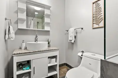 a white bathroom with a sink and a toilet at Stunning Mountain Views - Pool&HotTub - King Bed - BBQ in Canmore