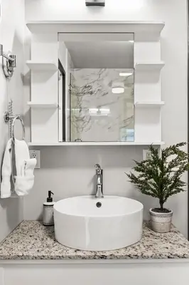 a white bathroom with a sink and a mirror at Stunning Mountain Views - Pool&HotTub - King Bed - BBQ in Canmore