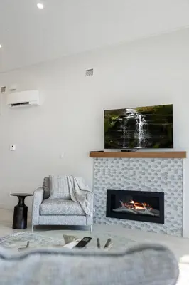 a living room with a couch and a fireplace at Beachfront Luxury Suite #21 at THE BEACH HOUSE in Campbell River