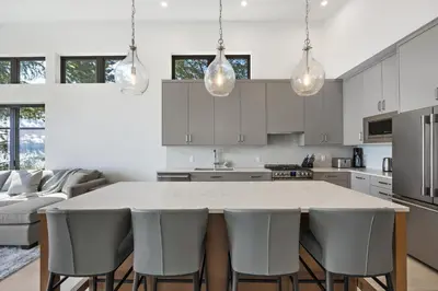 a kitchen with a large white table and chairs at Beachfront Luxury Suite #21 at THE BEACH HOUSE in Campbell River