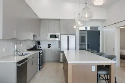 a kitchen with white cabinets and a white counter top at Beachfront Luxury Suite #21 at THE BEACH HOUSE in Campbell River