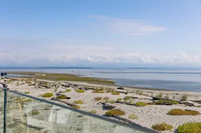 a view of a beach with the ocean in the background at Beachfront Luxury Suite #21 at THE BEACH HOUSE in Campbell River