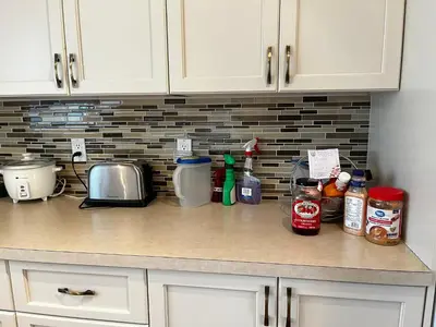 a kitchen counter with a counter top with condiments at Beddington masteroom close airport! in Calgary