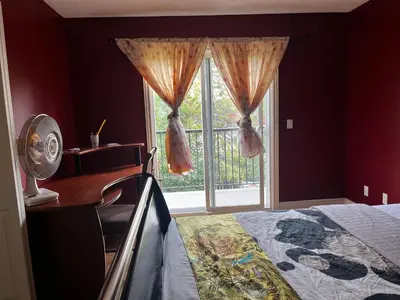 a bedroom with a bed and a large window at Beddington masteroom close airport! in Calgary