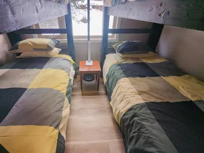 two twin beds in a room with a window at 2 Bedroom and Wall Bed Mountain Getaway Ski In Ski Out Condo with Hot Pools Sleeps 8 in Panorama
