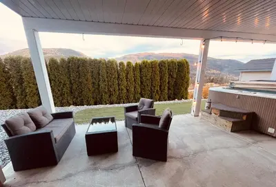 a patio with couches and chairs and a view of mountains at Relaxing 3 bedroom suite, near Silver Star Resort in Vernon
