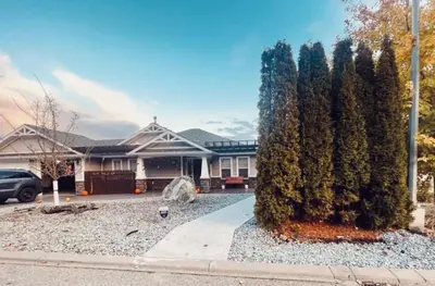 a house with a large tree in front of it at Relaxing 3 bedroom suite, near Silver Star Resort in Vernon