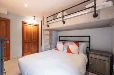 a bedroom with a white bed with red pillows at Treeline by Outpost Whistler in Whistler