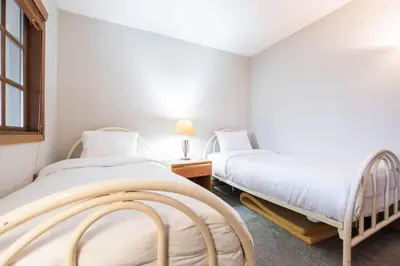 two beds in a room with white walls at Foxglove by Outpost Whistler in Whistler
