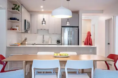 a kitchen with a wooden table and white chairs at Hygge Haus by Revelstoke Vacations in Revelstoke