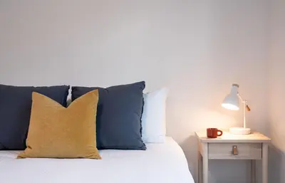 a bed with blue and white pillows and a lamp at Hygge Haus by Revelstoke Vacations in Revelstoke