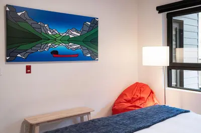 a bedroom with a bed and a painting on the wall at Hygge Haus by Revelstoke Vacations in Revelstoke