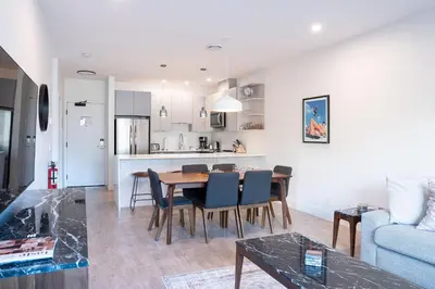 a living room and kitchen with a table and chairs at Mountainside Revival by Revelstoke Vacations in Revelstoke
