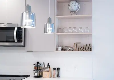 a kitchen with white cabinets and a counter top at Mountainside Revival by Revelstoke Vacations in Revelstoke