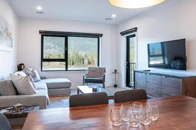 a living room with a table with wine glasses on it at Mountainside Revival by Revelstoke Vacations in Revelstoke