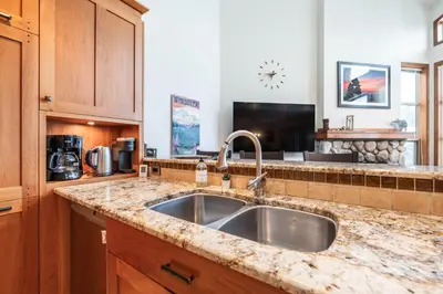 a kitchen with a sink and a counter top at Blackcomb Greens by Outpost Whistler in Whistler