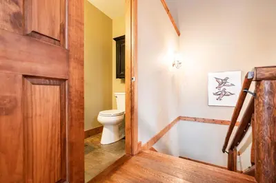 a bathroom with a toilet and a wooden door at Spruce Grove Chalet by Outpost Whistler in Whistler