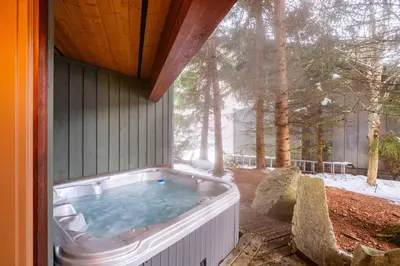 a hot tub on the side of a house at Spruce Grove Chalet by Outpost Whistler in Whistler