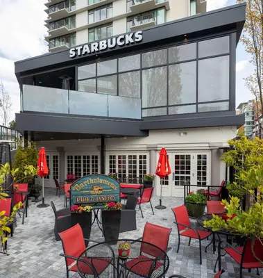 a patio with red chairs and tables in front of a building at DoubleTree by Hilton Hotel & Suites Victoria in Victoria
