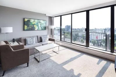 a living room with a couch and a large window at DoubleTree by Hilton Hotel & Suites Victoria in Victoria
