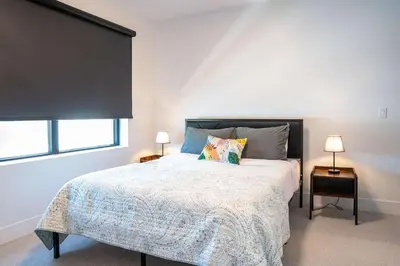 a bedroom with a large bed and two lamps at Revytalise - Cozy 3 Bedroom Condo in Revelstoke
